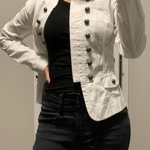 White blazer with black buttons.